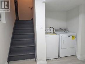 Pickering (West Shore) apartment for rent - A staircase with a washing machine and dryer in a small room.