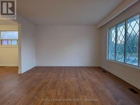 Pickering (West Shore) apartment for rent - A room with wooden flooring and a window with a view of a building outside.