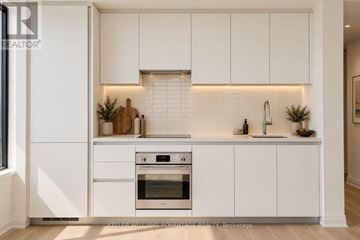 Mississauga (City Centre) condo for rent - A modern kitchen with white cabinets and a stainless steel oven.
