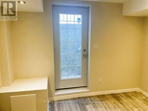 Milton (Cl Clarke) apartment for rent - A white door with a glass window is in a room with a wooden floor.