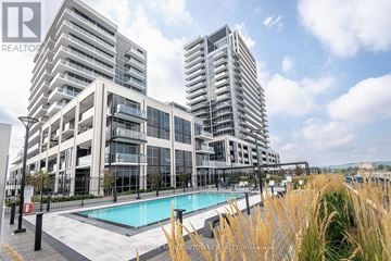 Milton (Tm Timberlea) condo for rent - A modern building with a pool in front.