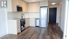 Milton (Tm Timberlea) condo for rent - A kitchen with a refrigerator, oven, and microwave.