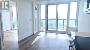 Milton (Tm Timberlea) condo for rent - A spacious room with a large window overlooking a cityscape.