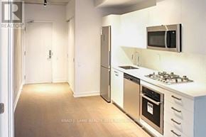 Toronto (Waterfront Communities) condo for rent - A kitchen with white appliances and a white counter top.