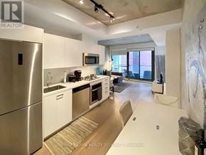 Toronto (Waterfront Communities) condo for rent - A modern kitchen with stainless steel appliances and white cabinets.