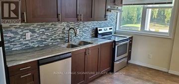 Whitchurch-Stouffville multi-family for rent - A kitchen with a stone counter top and a window.