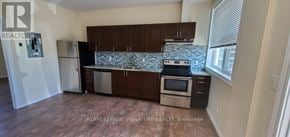 Whitchurch-Stouffville multi-family for rent - A kitchen with a refrigerator, stove, and cabinets.