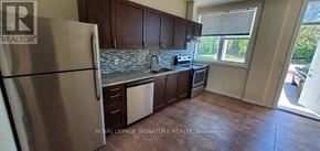 Whitchurch-Stouffville multi-family for rent - A kitchen with a refrigerator, cabinets, and a window.