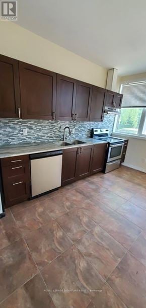 Whitchurch-Stouffville multi-family for rent - A kitchen with brown cabinets and a stone counter.
