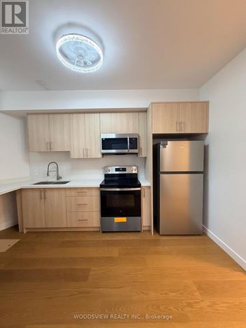 Toronto (Junction Area) apartment for rent - A kitchen with wooden cabinets and stainless steel appliances.