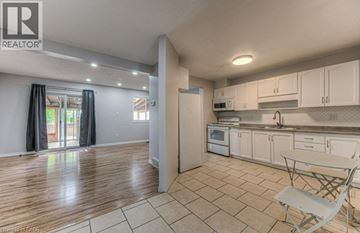 Cambridge townhouse for rent - A kitchen with white cabinets and a wooden floor.