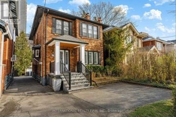 Toronto (Yonge-Eglinton) apartment for rent - A brick house with a black gate and a small front yard.