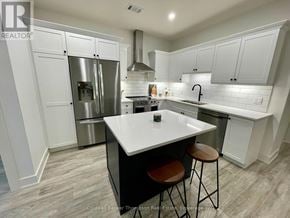 Huntsville (Chaffey) condo for rent - A modern kitchen with white cabinets and a central island.
