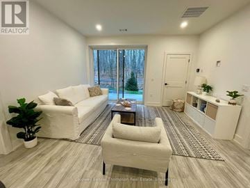 Huntsville (Chaffey) condo for rent - A well-lit living room with a white sofa and a coffee table.