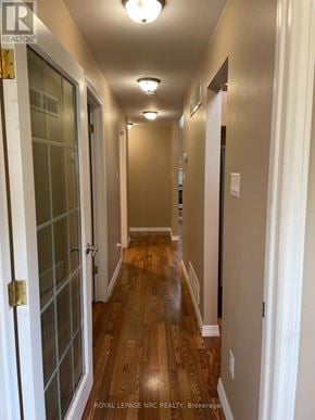 Fort Erie (Ridgeway) apartment for rent - A long hallway with wood floors and white walls.