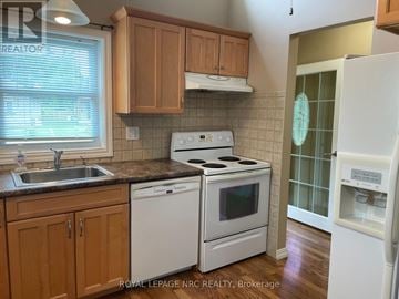 Fort Erie (Ridgeway) apartment for rent - A kitchen with a white stove top oven and white dishwasher.