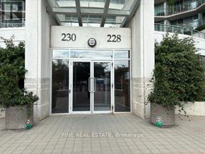 Toronto (Waterfront Communities) condo for rent - The image shows the entrance to a building with the numbers 230 and 228 on the wall above the glass doors.