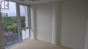 Toronto (Annex) condo for rent - A room with a view of a residential area through a large window.