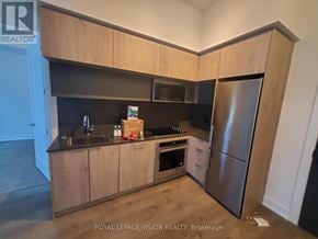 Toronto (Bayview Village) condo for rent - A kitchen with wooden cabinets and a stainless steel refrigerator.