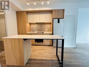 Mississauga (City Centre) condo for rent - A kitchen with wooden cabinets and a white countertop.