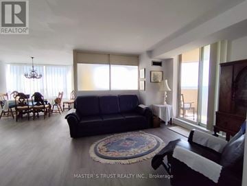 Mississauga (City Centre) condo for rent - A living room with a blue couch and a rug.