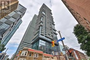 Toronto (Church-Yonge Corridor) condo for rent - A tall building with a unique design stands out in a cityscape.