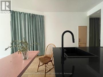 Toronto (Kensington-Chinatown) townhouse for rent - A kitchen with a black counter and a chair.