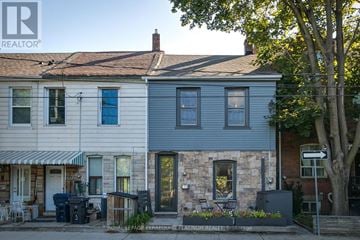 Toronto (South Riverdale) townhouse for rent - A house with a blue door and windows is shown.