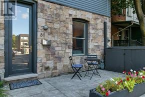Toronto (South Riverdale) townhouse for rent - A patio with a table and chairs is in front of a stone building.