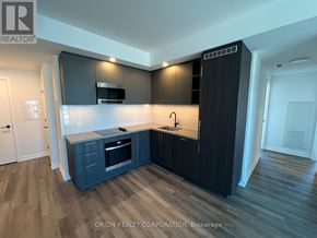 Vaughan (Vaughan Corporate Centre) condo for rent - A modern kitchen with dark wood cabinets and a white countertop.
