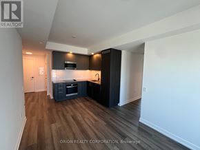 Vaughan (Vaughan Corporate Centre) condo for rent - A kitchen with dark wood floors and white walls.