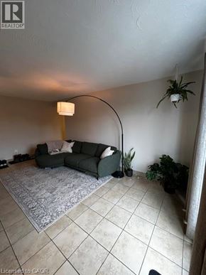 New Hamburg apartment for rent - A living room with a grey couch and a rug.
