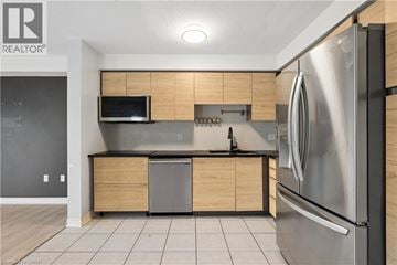 Guelph townhouse for rent - A modern kitchen with a stainless steel refrigerator and wooden cabinets.