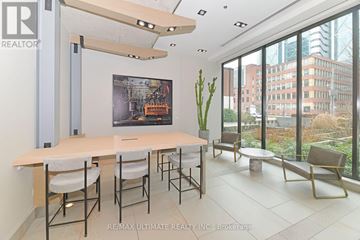Toronto (Waterfront Communities) condo for rent - A conference room with a long table and chairs, a poster on the wall, and a view of the city outside the windows.