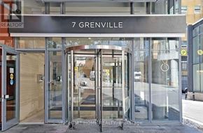 Toronto (Bay Street Corridor) condo for rent - The front of a building with a glass door and a sign that says 7 Grenville.
