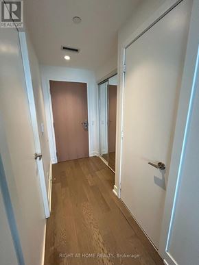 Toronto (Bay Street Corridor) condo for rent - A hallway with a wooden floor and white walls.