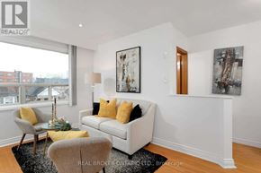 Toronto (Oakwood Village) apartment for rent - A living room with a white couch, yellow pillows, and a large window.