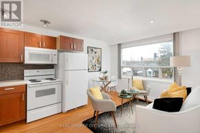 Toronto (Oakwood Village) apartment for rent - A well-lit kitchen with white appliances and wooden cabinets.