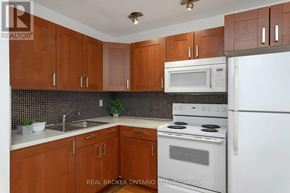 Toronto (Oakwood Village) apartment for rent - A kitchen with brown cabinets and white appliances.