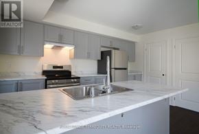 Clarington (Bowmanville) townhouse for rent - A kitchen with a marble counter top and stainless steel appliances.