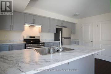 Clarington (Bowmanville) townhouse for rent - A kitchen with a marble counter top and stainless steel appliances.