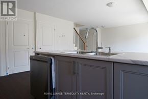 Clarington (Bowmanville) townhouse for rent - A kitchen with dark brown cabinets and a white counter top.