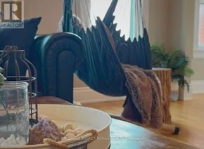 Barrie (Lakeshore) apartment for rent - A room with a couch, a table with a bowl of snacks, and a plant.
