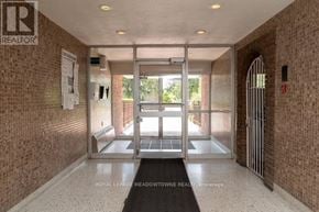Mississauga (Port Credit) multi-family for rent - A hallway with a brick wall and a doorway leading outside.