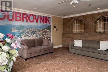 Mississauga (Port Credit) multi-family for rent - A living room with a couch and a poster of Dubrovnik on the wall.