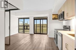 Welland (Broadway) condo for rent - A modern kitchen with wooden floors and a large window.