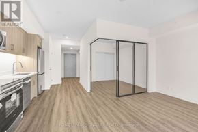 Welland (Broadway) condo for rent - A well-lit, empty room with wooden flooring and a glass partition wall.