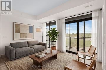 Welland (Broadway) condo for rent - A living room with a grey couch, a wooden coffee table, and a painting on the wall.