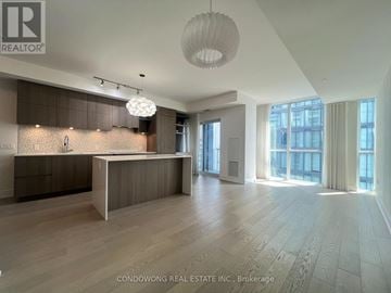 Toronto (Annex) condo for rent - A spacious kitchen with wooden floors and a large island.