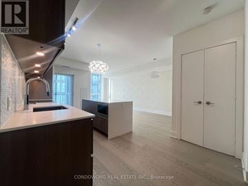Toronto (Annex) condo for rent - A modern kitchen with dark wood cabinets and a white countertop.
